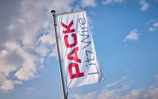 Weiße Fahne mit dem Schriftzug „PACK Litzwire“ vor blauem Himmel