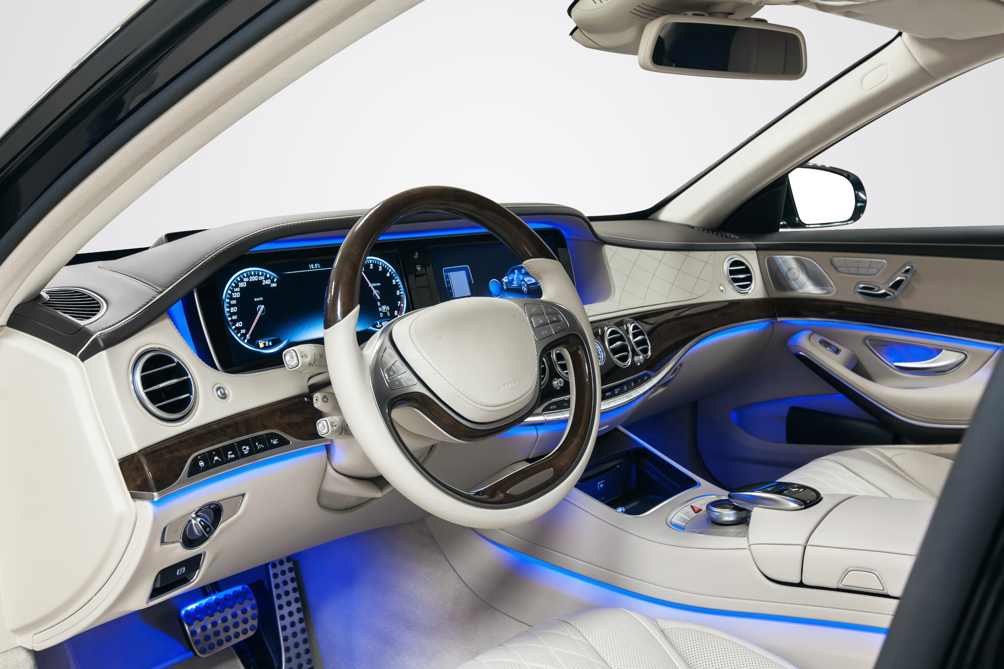 Innenraum eines modernen Fahrzeugs mit Lenkrad, digitalem Kombiinstrument und beleuchteter Mittelkonsole