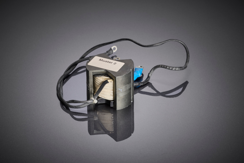 Der Leistungsübertrager zeigt die kompakte Wicklungsauslegung mit HF-Litze, die speziell für hohe Dauerströme, lange Lebensdauer und den Einsatz unter Bahn-typischen Schock- und Vibrationsbelastungen entwickelt wurde.